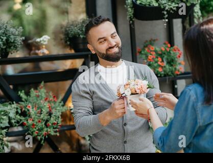 Vendere piante, creare bouquet in negozio di fiori e piccole imprese in primavera e estate Foto Stock