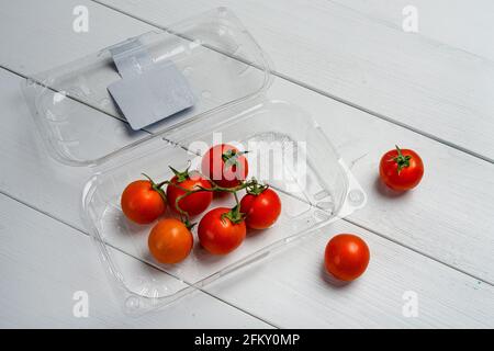 alcuni pomodori ciliegini in un vassoio di plastica Foto Stock