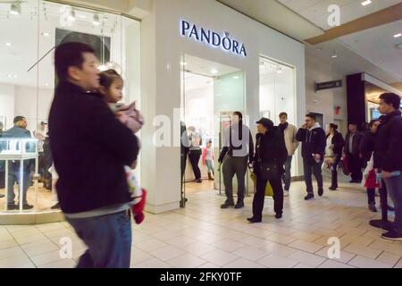 New York, Stati Uniti. 24 Dic 2016. Gli acquirenti dell'ultimo minuto passano per il negozio di gioielli Pandora nel Queens Center Mall nel quartiere delle Queens a New York la vigilia di Natale, sabato 24 dicembre 2016. Uno studio riporta che la stagione degli acquisti natalizi, novembre e dicembre, rappresenta ora meno del 21% delle vendite dei negozi fisici, in calo rispetto al picco del 25%. (Foto di Richard B. Levine) Credit: Sipa USA/Alamy Live News Foto Stock