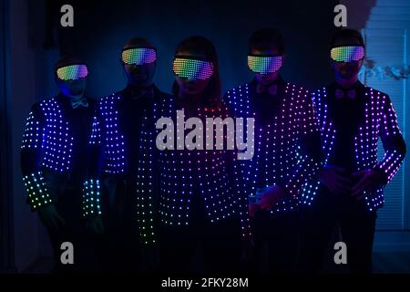 persone in abiti chiari a led su sfondo scuro Foto Stock