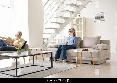 Una coppia anziana di famiglia trascorre del tempo a casa in un moderno soggiorno. Foto Stock
