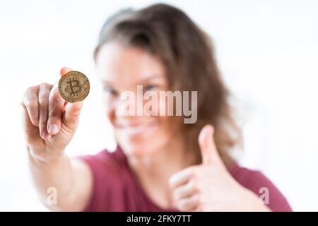 moneta di bitcoin nella mano di un'impresa giovane attraente donna Foto Stock