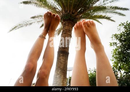 Piedi in aria contro palme e cielo blu Foto Stock