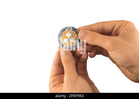 La mano maschio tiene un isolato di criptovaluta a moneta ondulata su bianco foto di sfondo Foto Stock