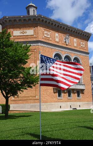 Prima chiesa Battista, a El Dorado, Arkansas, vola la bandiera americana di fronte alla loro chiesa. Il cielo è soleggiato e blu. Foto Stock