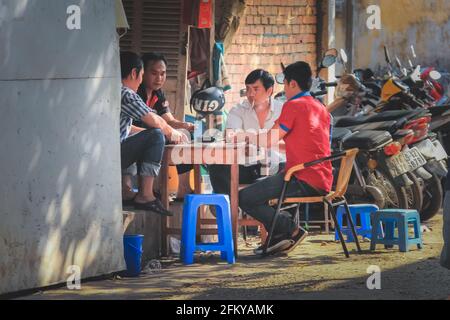 Ho Chi Minh City, Vietnam - Marzo 10 2014: Uomini locali vietnamiti gioco d'azzardo gioco di carte di poker di strada su un discreto, strada urbana a Saigo Foto Stock