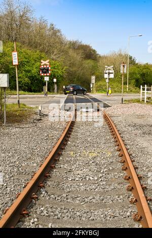 Bridgend, Galles - Aprile 2021: Binario ferroviario inutilizzato che attraversa una strada principale per una fabbrica sulla Waterton Industrial Estate a Bridgend Foto Stock
