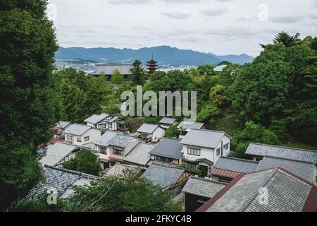 Vista aerea sui tetti e Toyokuni santuario a cinque piani pagoda circondato dalla foresta di Miyajima, Giappone Foto Stock