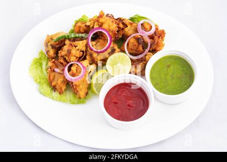 Deep Fried speziato cibo indiano di strada con vari nomi come Cipolla Bhajji Pyaj Pakora o Pakore Pyaaj Ke Pakode o. Pakoda Kanda Bhaji Pyaaz Baji servire Foto Stock