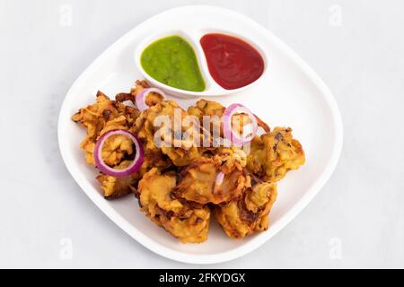 Cibo di strada subcontinentale indiano con vari nomi come la cipolla Bhajji Pyaj Pakora o Pakore Pyaaj Ke Pakode o Pakoda Kanda Bhaji Pyaaz Baji servito Foto Stock