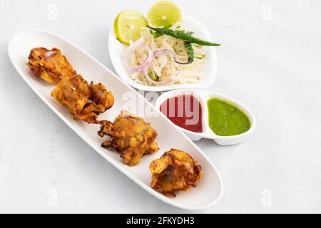 Indiano Subcontinental Tea Time Chaat spuntini con vari nomi come Cipolla Bhajji Pyaj Pakora o Pakore Punjabi Pyaaj Ke Pakode O Pakoda Kanda Bhaji P. Foto Stock