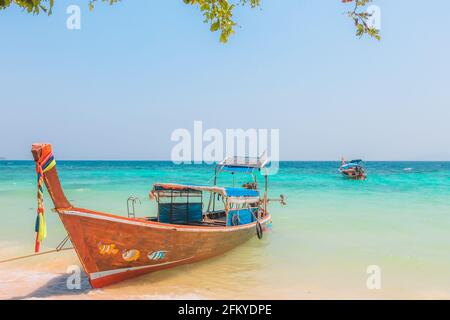 Una colorata barca da pesca tailandese tradizionale a coda lunga sulla spiaggia tropicale di Loh Moo Dee Beach a Koh Phi Phi, Thailandia. Foto Stock