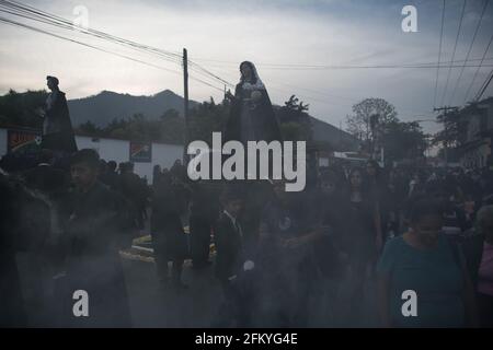 Devoti manifestanti portano una anda con la Vergine Maria attraverso le strade affumicate di Antigua durante la processione Semana Santa, una tradizione sacra. Foto Stock