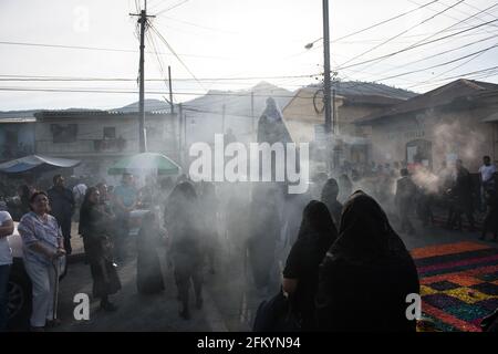 Devoti manifestanti portano una anda con la Vergine Maria attraverso le strade affumicate di Antigua durante la processione Semana Santa, una tradizione sacra. Foto Stock