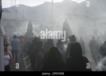 Devoti manifestanti portano una anda con la Vergine Maria attraverso le strade affumicate di Antigua durante la processione Semana Santa, una tradizione sacra. Foto Stock