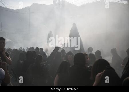 Devoti manifestanti portano una anda con la Vergine Maria attraverso le strade affumicate di Antigua durante la processione Semana Santa, una tradizione sacra. Foto Stock