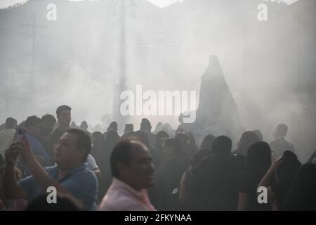 Devoti manifestanti portano una anda con la Vergine Maria attraverso le strade affumicate di Antigua durante la processione Semana Santa, una tradizione sacra. Foto Stock