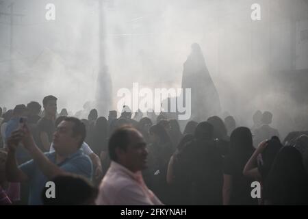 Devoti manifestanti portano una anda con la Vergine Maria attraverso le strade affumicate di Antigua durante la processione Semana Santa, una tradizione sacra. Foto Stock