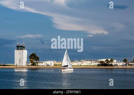 Torre di controllo all'aeroporto Albert Whittled con barca a vela in primo piano sulla Baia di Tampa. San Pietroburgo, Florida Foto Stock