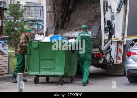Spazzatura uomini che operano camion spazzatura, raccolta rifiuti solidi domestici, Mosca, aprile 2021 Foto Stock