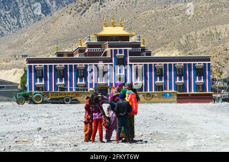 Loba donne e bambini di fronte a un colorato tempio buddista a Jomsom, regione di Mustang, Nepal. Foto Stock