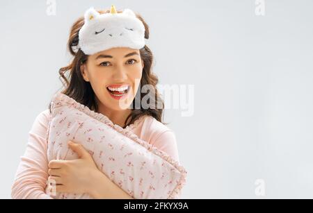 Bella giovane donna indossa la Sleepwear su sfondo grigio parete. Foto Stock