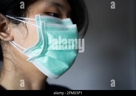Un uomo che indossa due maschere usa e getta Foto Stock