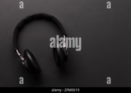 Cuffie wireless su sfondo scuro. Vista dall'alto in piano con spazio per la copia Foto Stock