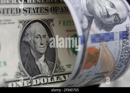 banconote da 100 dollari leggermente rotolate su banconote da 1 dollaro per scopo del progetto Foto Stock