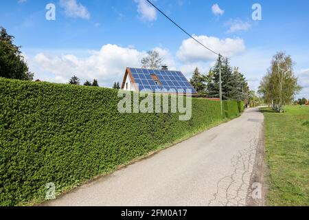 Lipsia, Germania. 03 maggio 2021. Una casa singola con celle solari sul tetto si erge dietro una siepe verde. Credit: Jan Woitas/dpa-Zentralbild/ZB/dpa/Alamy Live News Foto Stock