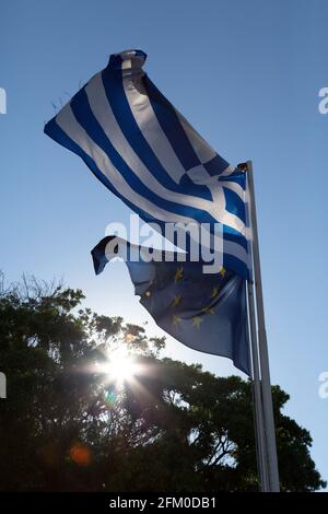 Le bandiere della Grecia e dell'Unione europea volano nella città di Rodi, in Grecia. La bandiera greca vola sopra la bandiera dell'UE sul palo. Foto Stock
