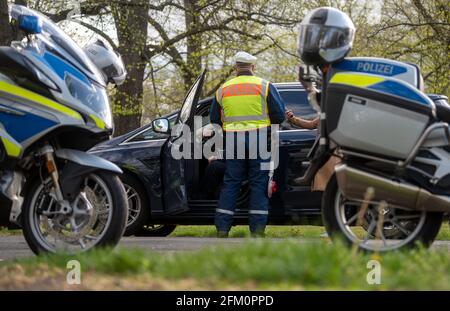 Lipsia, Germania. 05 maggio 2021. Un agente di polizia della polizia stradale di Lipsia controlla un automobilista su Jahnallee a Lipsia. Il dipartimento di polizia di Lipsia sta effettuando i controlli nell'ambito della campagna di sicurezza stradale statale sicher.mobil.leben. L'obiettivo è quello di aumentare la sicurezza stradale per tutti i modi di trasporto coinvolti nel traffico stradale. Credit: Hendrik Schmidt/dpa-Zentralbild/ZB/dpa/Alamy Live News Foto Stock