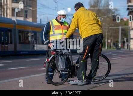 Lipsia, Germania. 05 maggio 2021. Un agente di polizia della polizia stradale di Lipsia controlla un ciclista su Jahnallee a Lipsia. Il dipartimento di polizia di Lipsia sta effettuando i controlli nell'ambito della campagna di sicurezza stradale statale sicher.mobil.leben. L'obiettivo è quello di aumentare la sicurezza stradale per tutti i modi di trasporto coinvolti nel traffico stradale. Credit: Hendrik Schmidt/dpa-Zentralbild/ZB/dpa/Alamy Live News Foto Stock