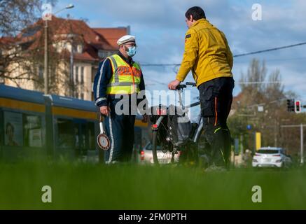 Lipsia, Germania. 05 maggio 2021. Un agente di polizia della polizia stradale di Lipsia controlla un ciclista su Jahnallee a Lipsia. Il dipartimento di polizia di Lipsia sta effettuando i controlli nell'ambito della campagna di sicurezza stradale statale sicher.mobil.leben. L'obiettivo è quello di aumentare la sicurezza stradale per tutti i modi di trasporto coinvolti nel traffico stradale. Credit: Hendrik Schmidt/dpa-Zentralbild/ZB/dpa/Alamy Live News Foto Stock