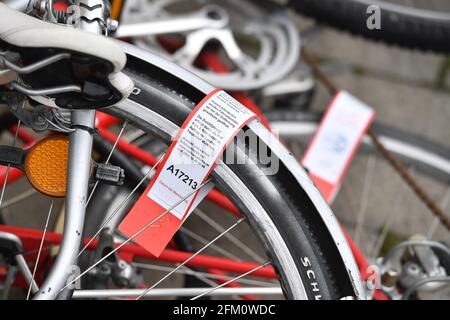 Monaco, Germania. 05 maggio 2021. Le vecchie biciclette si trovano su un marciapiede di fronte alla stazione della metropolitana Odeonsplatz. Le ruote rottami e ovviamente abbandonate sono contrassegnate con un benderolo. Questo benderolo indica che la ruota verrà rimossa dopo quattro settimane. | utilizzo in tutto il mondo credito: dpa/Alamy Live News Foto Stock