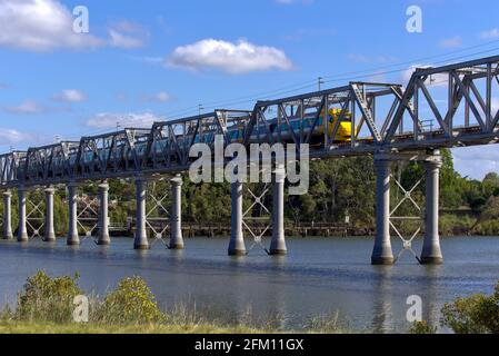 Treno di inclinazione Queensland Rail che attraversa il ponte ferroviario del Burnett River Bundaberg Queensland Australia Foto Stock