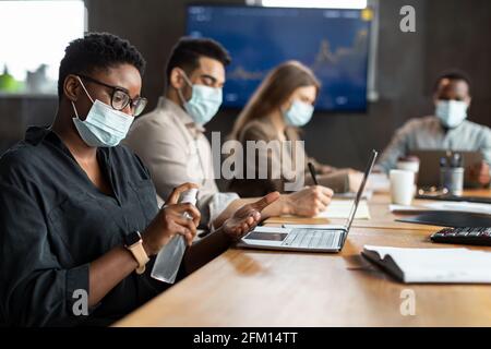 Persone internazionali che indossano maschere mediche con igienizzatore Foto Stock
