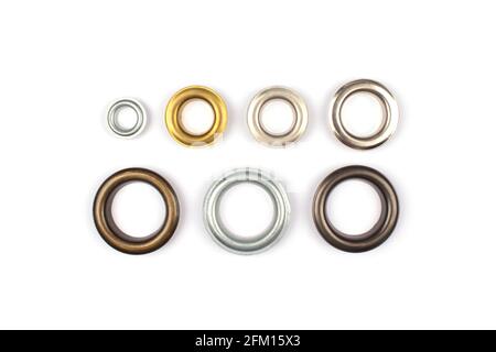 Catalogo foto di diversi occhielli o rivetti metallici multicolore in ottone - tendine anelli per il fissaggio del tessuto al cornicione, isolati su bianco Foto Stock