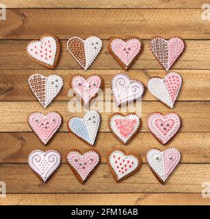 Dolce Natale cuore a forma di zenzero biscotti raccolta con colorato zucchero a velo decorazione, su vecchio sfondo di legno Foto Stock