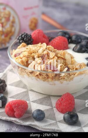 yogurt, muesli e bacche in ciotola su fondo di legno Foto Stock