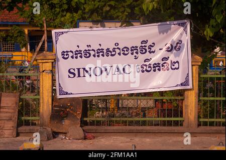 Phnom Penh, Cambogia. 5 maggio 2021. Il governo cambogiano sta cercando di vaccinare ogni persona che vive in una zona rossa (area ad alto rischio). Qui, un sito di vaccinazione mostra un banner bilingue, sia in inglese che in Khmer, che dice che è possibile ottenere il vaccino cinese, SINOVAC. Il governo ha deciso di sollevare il blocco nella maggior parte di Phnom Penh a mezzanotte del 5 maggio dopo 3 settimane di chiusura totale della città. Alcune zone rosse avranno ancora restrizioni a causa dell'aumento COVID - 19. Credito: Kraig Lieb / Alamy Live News Foto Stock