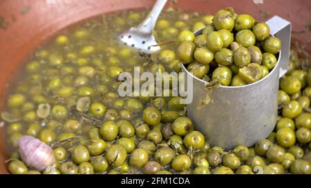 Marinato con olive alle erbe in una grande ciotola in ceramica in mostra sul mercato. Primo piano. Foto Stock