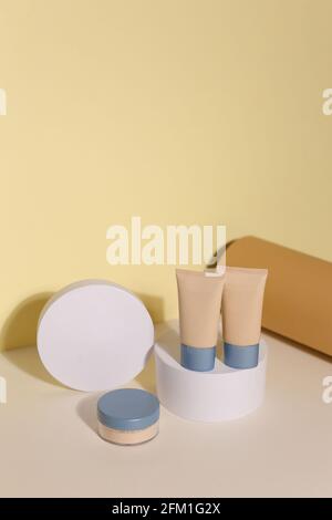 Campioni di make-up della faccia della fondazione. Set di fondazioni cosmetiche liquide o panna bb in colore bottiglia. Preparare gli strisci isolati su sfondo beige Foto Stock