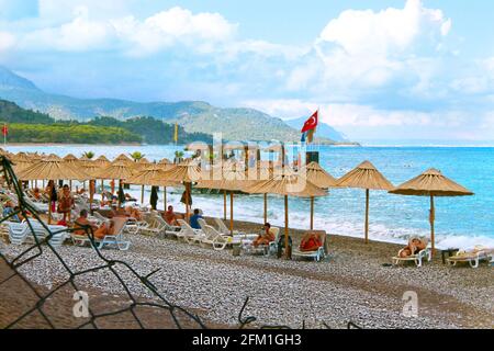 Kemer, Turchia - 09 23 2015: Hotel Crystal Aura. Spiaggia con lettini, ombrelloni e persone. Mare, montagne, palme, molo. Bandiera della Turchia. Tempo libero e t Foto Stock