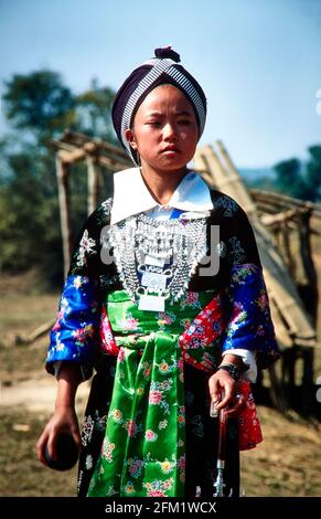 Una giovane donna Hmong, vestita in costume tradizionale, saluta il nuovo anno giocando a palla. Il gioco della palla con i giovani offre l'opportunità di ottenere t Foto Stock
