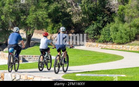 Padre e due figli cavalcano le loro biciclette su un sentiero a Middleton Beach, Ellen Cove, Albany, Australia Occidentale. Foto Stock