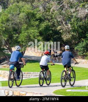 Padre e due figli cavalcano le loro biciclette su un sentiero a Middleton Beach, Ellen Cove, Albany, Australia Occidentale. Foto Stock