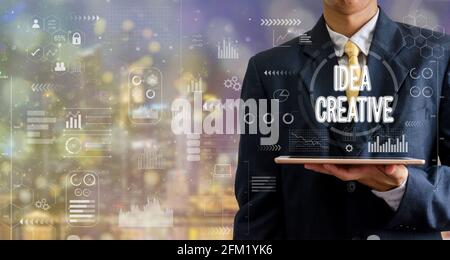 uomo d'affari che tiene un tablet computer idea creativa icona grafico astratto sfondi con bokeh. Foto Stock