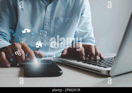 Uomo che utilizza l'app mobile e il computer portatile per lo shopping online. Concetto di finanza e marketing online per business.Man utilizzo di smartphone per l'invio di e-mail Foto Stock