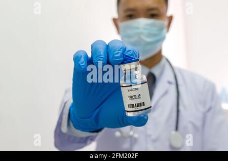 Medico o laborante che contiene una provetta per il vaccino COVID-19 o un vaccino per il coronavirus. Concetto di vaccino del coronavirus. Foto Stock